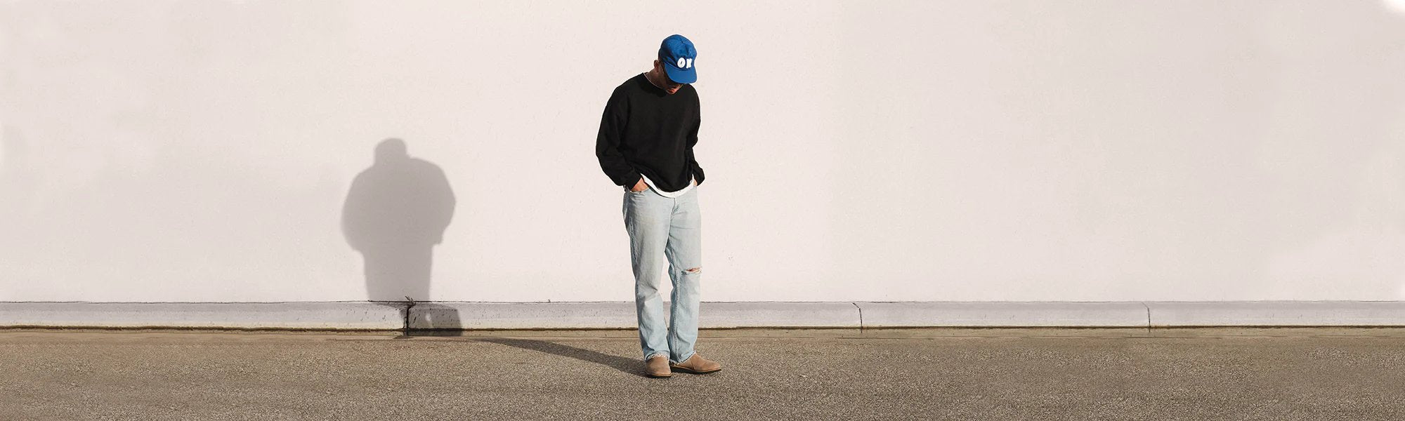 Shannon slouching in a chair wearing the Simple Taupe Original Clogs